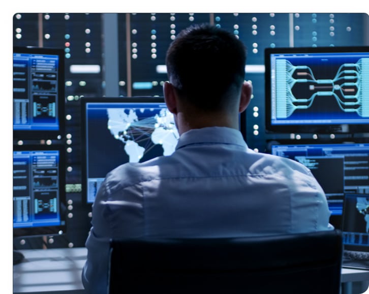 A man sits at a bank of computers